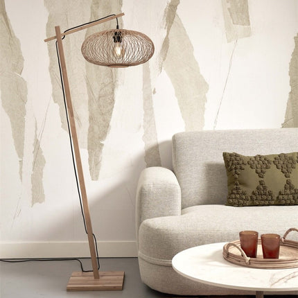 Lampadaire Cango bambou naturel posé près d'un canapé beige, pied bois incliné et abat-jour tressé