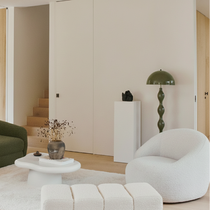 Lampadaire champignon vert olive posé sur un socle dans un salon épuré aux tons crème