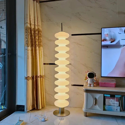 Lampadaire empilé blanc à intensité réglable près d'un canapé