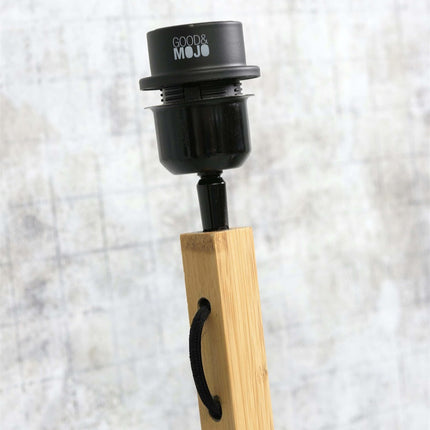 Gros plan sur la douille E27 noire fixée au pied en bambou, compatible avec une ampoule à vis classique jusqu'à 60 W.