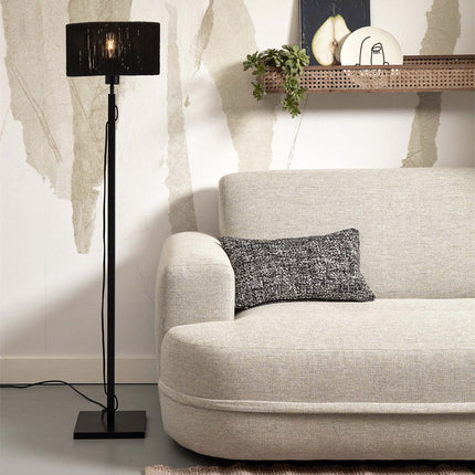 Lampadaire Iguazu en jute noir tissé et bambou dans un salon beige, allumé