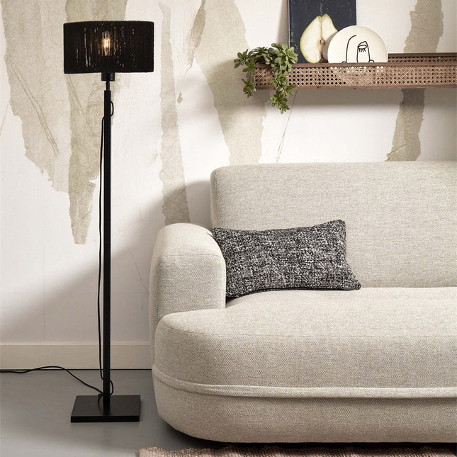 Lampadaire Iguazu en jute noir tissé et bambou dans un salon beige, allumé