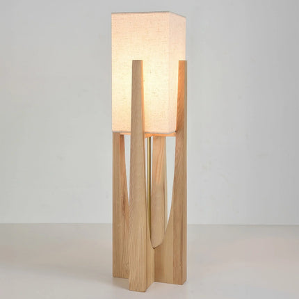 Lampadaire japonais en bois clair, grand modèle allumé sur fond neutre, silhouette élancée