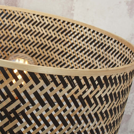 Détail en angle du motif tressé naturel et noir de l'abat-jour du lampadaire Java en bambou