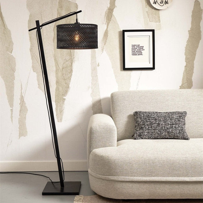 Vue d'ensemble du lampadaire Java, silhouette élancée noire et abat-jour en bambou tressé, posé au sol d'un salon clair