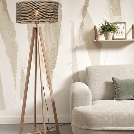 Lampadaire Java allumé, piètement en bambou naturel, dans un salon japandi près d'une étagère et d'un canapé en lin