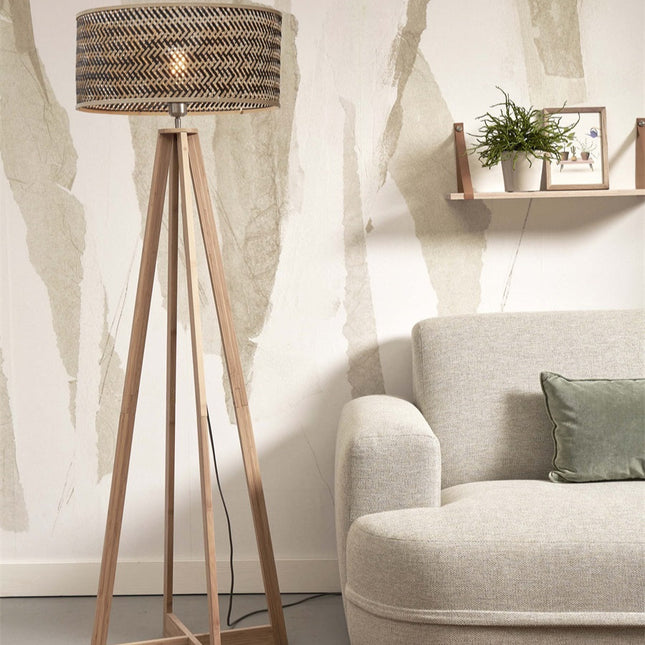 Lampadaire Java allumé, piètement en bambou naturel, dans un salon japandi près d'une étagère et d'un canapé en lin