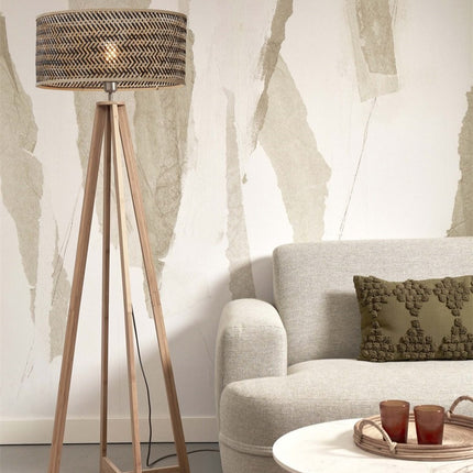 Lampadaire Java sur pieds en bambou naturel avec abat-jour tressé naturel et noir, dans un salon cosy près d'un canapé beige