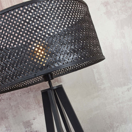Lampadaire Java bambou naturel à côté d'un fauteuil design et d'un tableau abstrait encadré