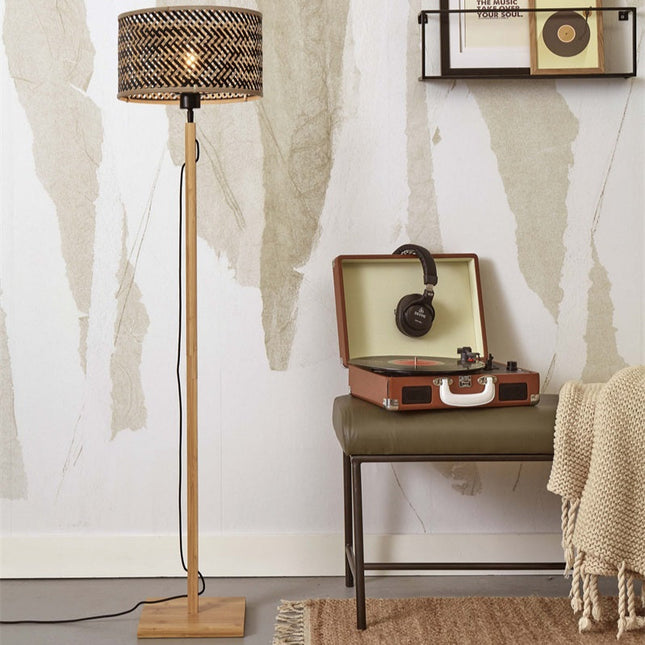Lampadaire Java bambou tressé naturel et noir posé près d'un meuble vintage et d'un tourne-disque
