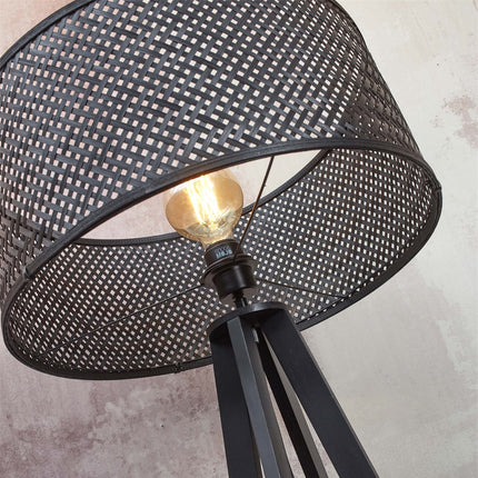 Lampadaire Java bambou naturel dans un salon avec canapé beige, étagère murale et vase noir sculptural