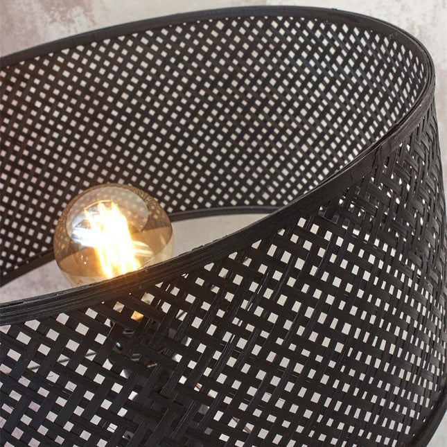 Gros plan sur le tressage de l'abat-jour en bambou noir du lampadaire Java, avec l'ampoule E27 visible