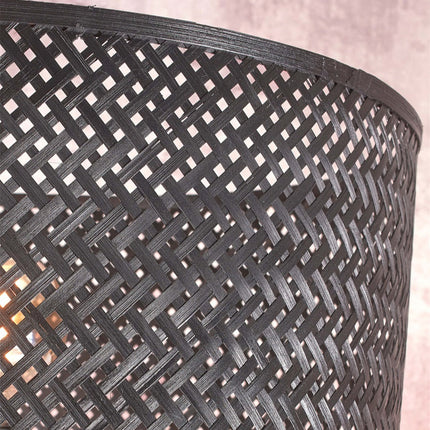 Gros plan sur le motif de tressage serré du bambou noir formant l'abat-jour du lampadaire Java