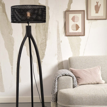 Lampadaire Java sur pieds tripodes en bambou noir allumé, silhouette élancée dans un salon lumineux