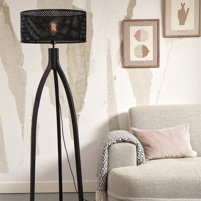 Lampadaire Java sur pieds tripodes en bambou noir allumé, silhouette élancée dans un salon lumineux