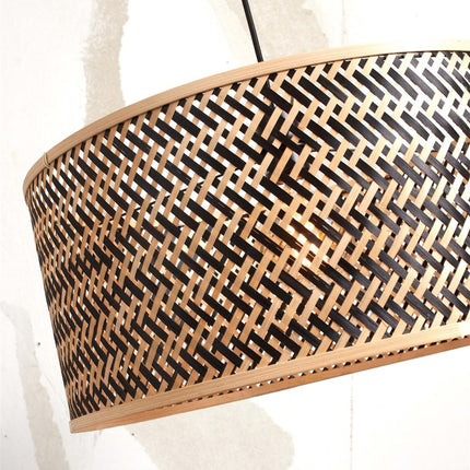 Gros plan sur le motif chevron tressé de l'abat-jour bambou du lampadaire Java XL, ampoule allumée
