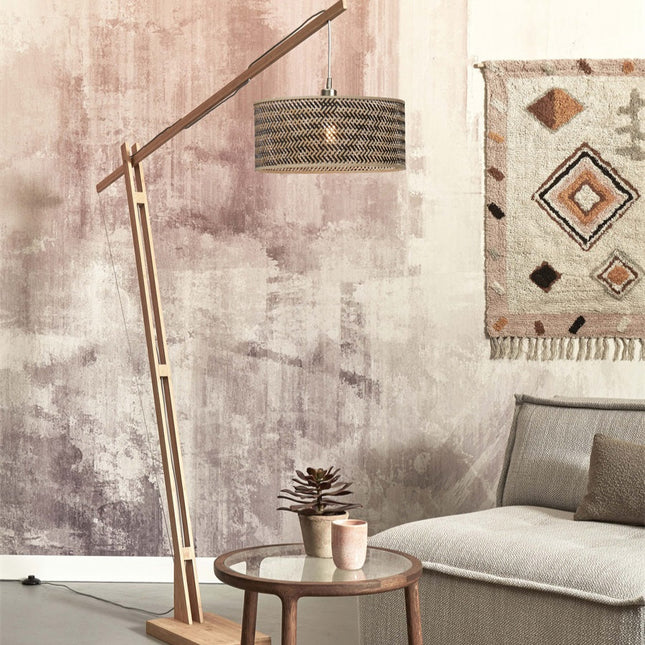 Lampadaire Java XL en bambou naturel et noir avec abat-jour tressé au-dessus d'un canapé