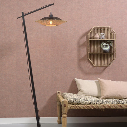 Lampadaire Kalimantan en bambou tressé, structure noire en potence, dans une chambre aux tons terracotta et rotin.