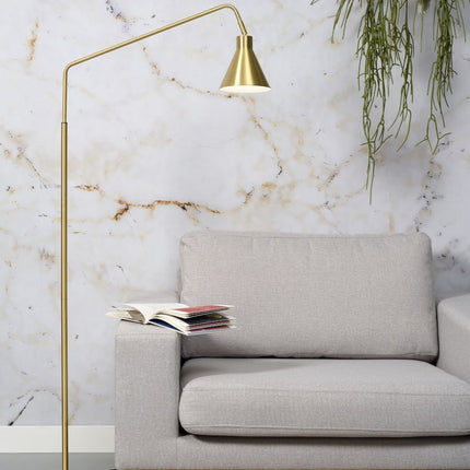 Lampadaire Lyon en fer doré, bras arqué et abat-jour conique au-dessus d'un canapé beige