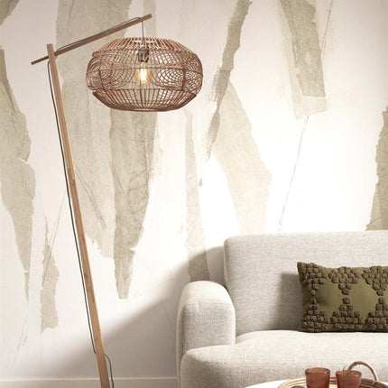 Lampadaire Madeira en bambou et rotin tressé naturel dans un salon, à côté d'un canapé beige