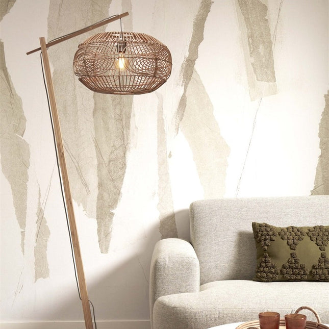 Lampadaire Madeira en bambou et rotin tressé naturel dans un salon, à côté d'un canapé beige