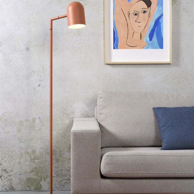 Lampadaire Marseille en fer terracotta près d'un canapé gris dans un salon lumineux