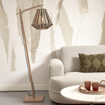 Lampadaire Merapi en bambou allumé à côté d'un canapé beige dans un salon lumineux