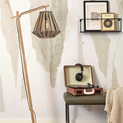 Lampadaire Merapi en bambou tressé naturel et noir dans un salon, près d'un tourne-disque vintage
