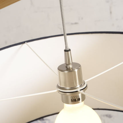 Détail de la douille en métal brossé et de l'ampoule du lampadaire Montblanc, sous l'abat-jour à l'intérieur clair.