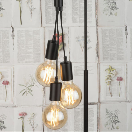 Gros plan sur les trois ampoules à filament du lampadaire Oslo suspendues à des câbles textiles noirs
