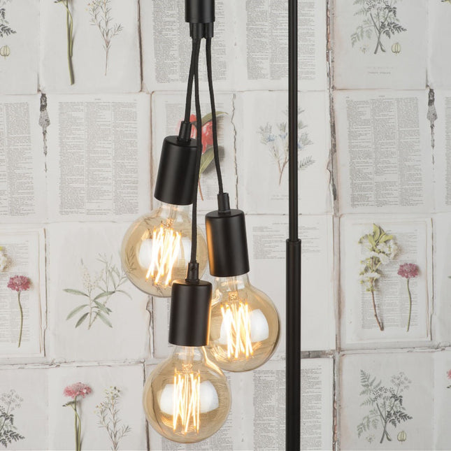 Gros plan sur les trois ampoules à filament du lampadaire Oslo suspendues à des câbles textiles noirs