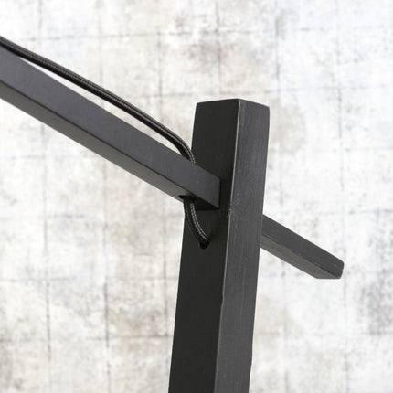 Détail de la jonction entre le bras en potence et le pied vertical en métal noir mat