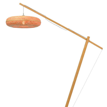 Lampadaire Palawan en bambou naturel détouré, bras arqué et abat-jour tressé allumé