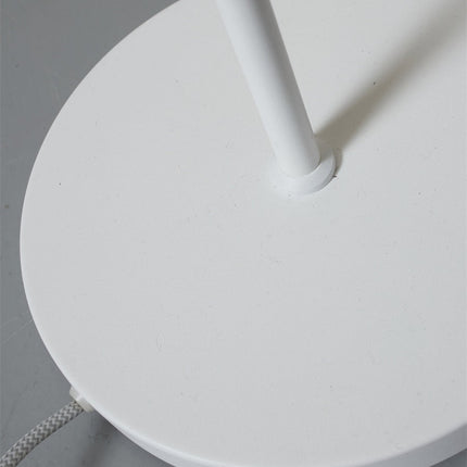 Détail du socle rond en fer blanc du lampadaire Porto, base stable et minimaliste.