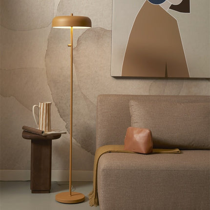 Lampadaire Porto moutarde près d'un canapé beige dans un salon cosy