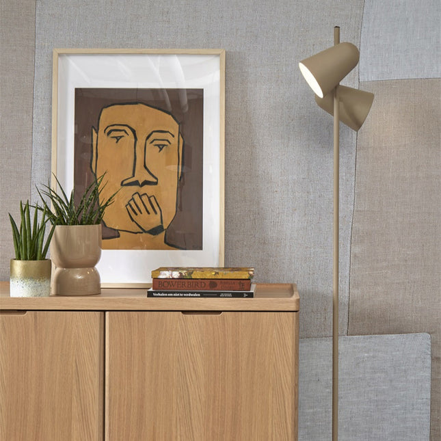 Lampadaire Salamanca sable posé près d'une console en bois avec plantes et livres