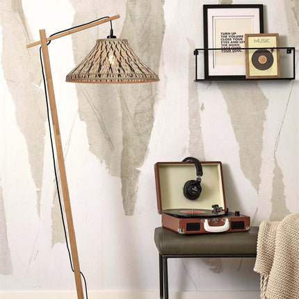 Lampadaire Tahiti en bambou tressé naturel et noir dans un salon cosy près d'une étagère murale