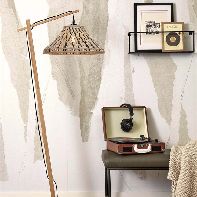 Lampadaire Tahiti en bambou tressé naturel et noir dans un salon cosy près d'une étagère murale
