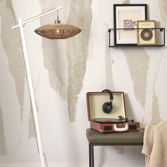 Lampadaire Tanami blanc à abat-jour disque en bambou tressé, installé dans un salon près d'une étagère et d'un tourne-disque