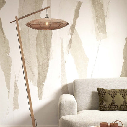 Lampadaire Tanami allumé, lumière tamisée filtrant à travers l'abat-jour en rotin tressé