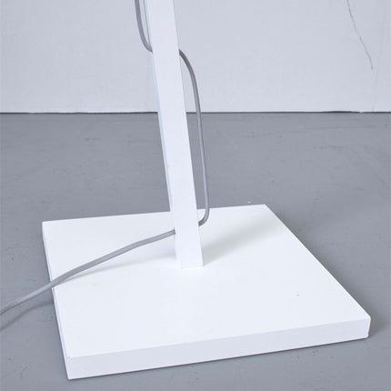Base carrée en métal blanc du lampadaire Tanami, posée au sol avec le passage du câble textile gris