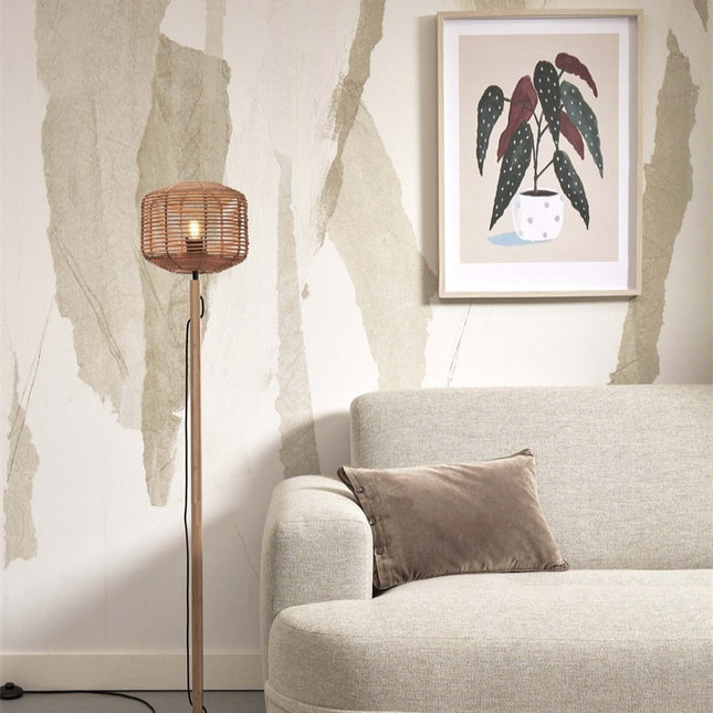 Lampadaire Tanami en rotin tressé et bambou naturel installé dans un salon près d'un canapé beige