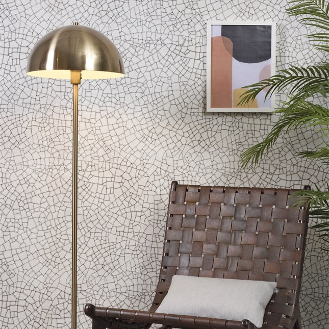 Lampadaire Toulouse allumé, dôme doré diffusant une lumière chaleureuse dans un salon cosy