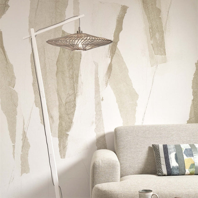 Lampadaire Zanzibar allumé, abat-jour tressé diffusant une lumière douce dans un salon épuré