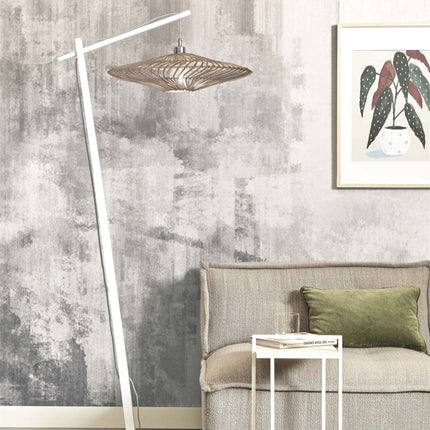 Lampadaire Zanzibar en rotin et bambou tressé, structure blanche, dans un salon face à un canapé beige