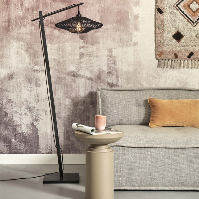 Lampadaire Zanzibar rotin et métal noir, ambiance chaleureuse près d'un canapé gris et d'un mur rosé