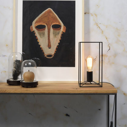 Lampe à poser Antwerp en fer noir posée sur une console en bois, ambiance déco japandi