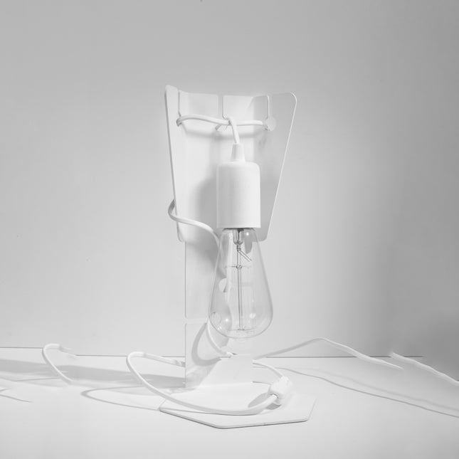 Lampe de bureau Arby en acier blanc éteinte sur fond gris, cordon enroulé et interrupteur