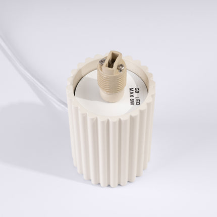Détail du culot G9 en céramique à l'intérieur du socle en aluminium beige