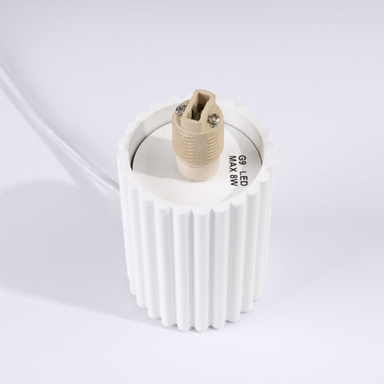 Détail du culot G9 en céramique à l'intérieur du socle en aluminium blanc